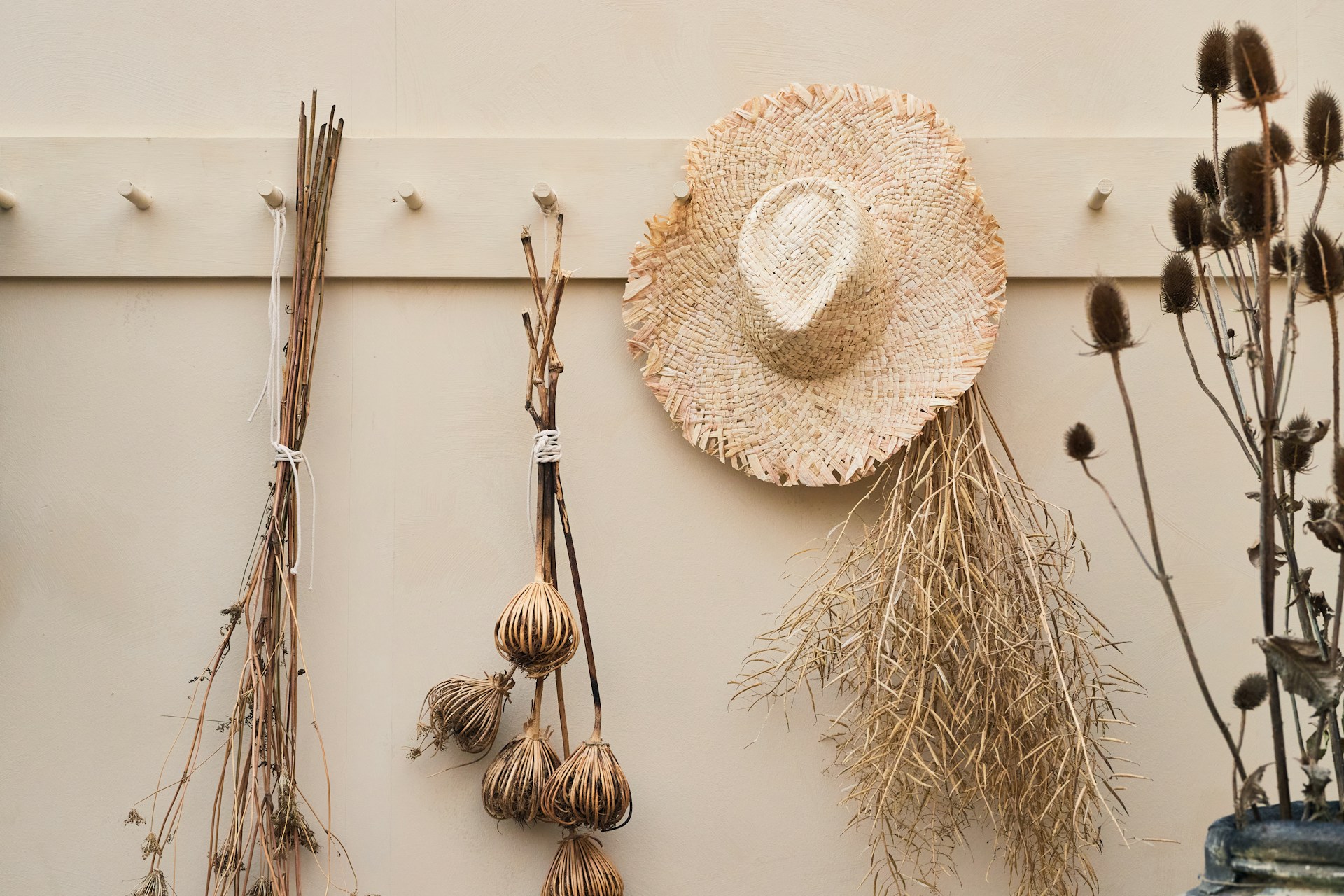 A wall with dried flowers and a straw hat. Photo by Olivie Strauss.